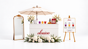 L’Or hosted drinks bar with ivory parasol, gold mirror, menu easel and white florals in a white studio